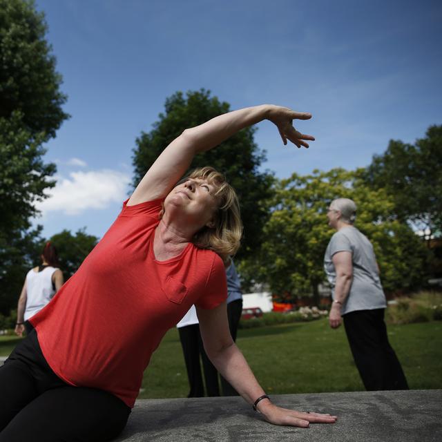 Des exercices physiques pour les seniors sont organisés avec d'autres tranches d'âges dans des parcs de Lausanne. [Keystone/AP Photo - Lefteris Pitarakis]