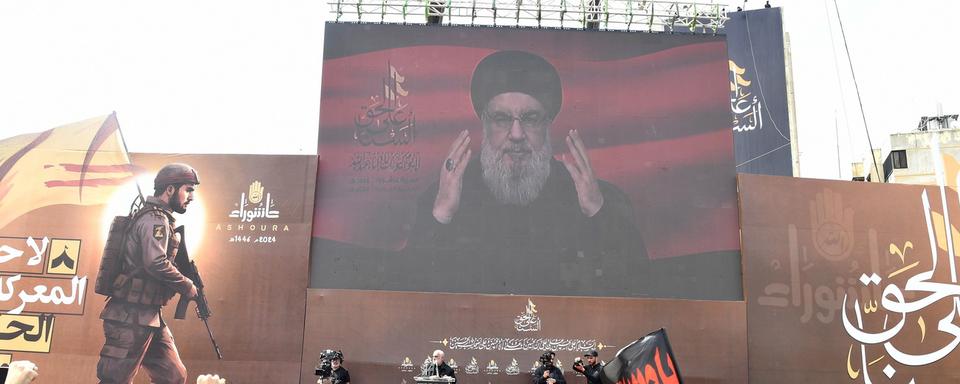 Des partisans du Hezbollah réagissent en regardant un discours télévisé de leur leader, Hassan Nasrallah, lors de célébration de la journée d'Achoura à Beyrouth, au Liban, le 17 juillet 2024 (image d'illustration). [keystone - Abbas Salman]