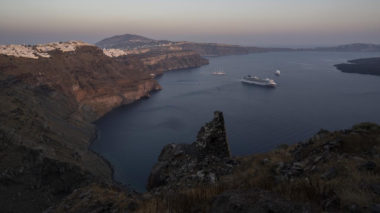 Un bateau de croisière dans la baie de l'île grecque de Santorin. [Keystone/AP Photo - Petros Giannakouris]