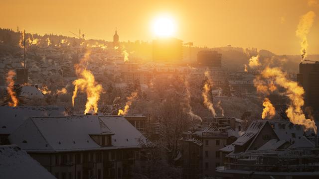 Rauchsaeulen von Kaminen waehrend dem Sonnenaufgang, fotografiert am Sonntag, 3. Dezember 2023 in Zuerich Wipkingen. (KEYSTONE/Christian Beutler) [Keystone - Christian Beutler]