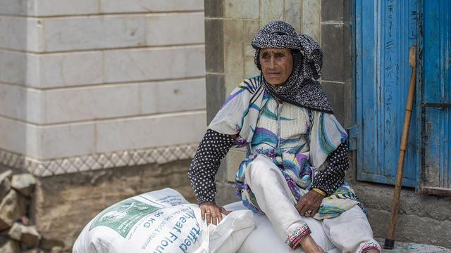 Au Yémen, une femme dans la ville de Taïz tient un sac distribué par le Programme alimentaire mondial (PAM). [AFP - Ahmad AL-BASHA]