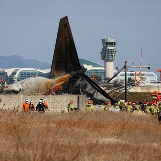 Les pompiers en action après le crash de l'avion à l'aéroport de Muan, en Corée du Sud. [Keystone]