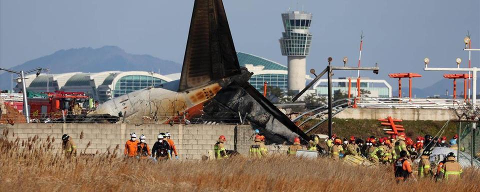 Les pompiers en action après le crash de l'avion à l'aéroport de Muan, en Corée du Sud. [Keystone]