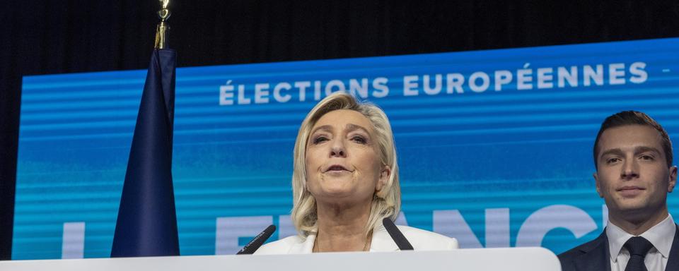 Marine le Pen, chef du parti parlementaire du Rassemblement National, prononce un discours à côté du président du RN Jordan Bardella. [Keystone]