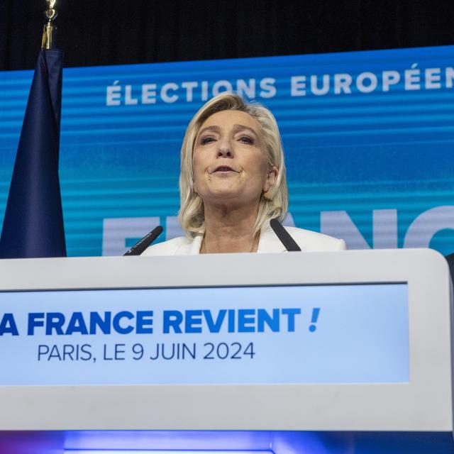 Marine le Pen, chef du parti parlementaire du Rassemblement National, prononce un discours à côté du président du RN Jordan Bardella. [Keystone]