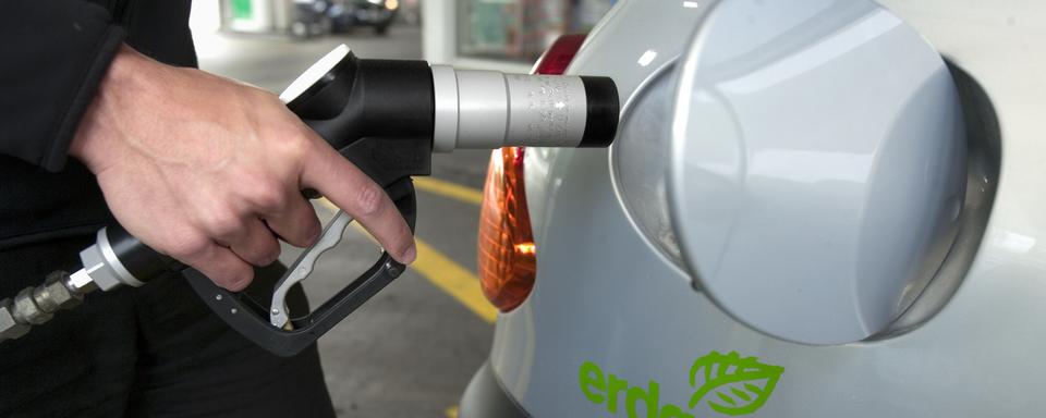 Un homme fait le plein de sa voiture à une station-service de gaz naturel en Suisse en 2006. [Keystone - Martin Ruetschi]