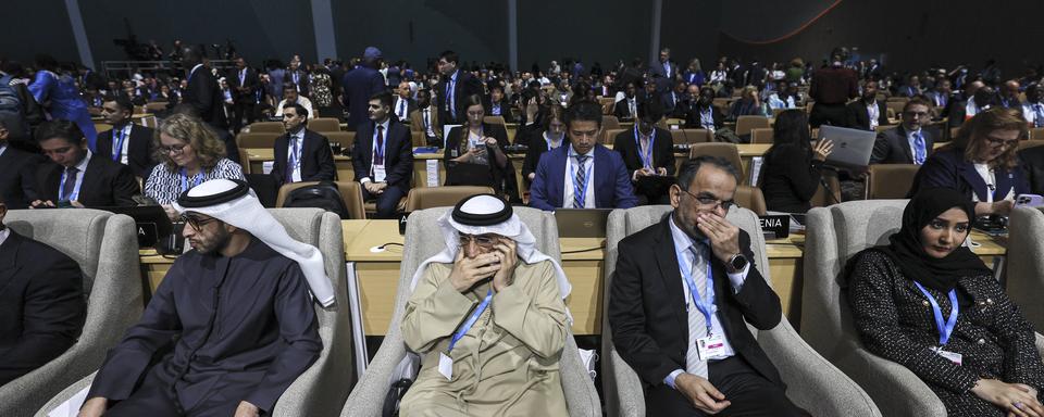 Des participants à la COP29 à Bakou attendent la cérémonie d'ouverture, lundi 11 novembre 2024. [EPA/Keystone - ANATOLY MALTSEV]