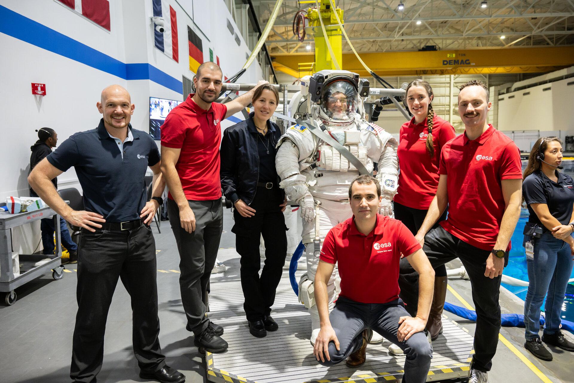 Les membres de la classe d'astronautes 2022 de l'ESA en visite au Centre spatial Johnson de la NASA à Houston, au Texas, où ils et elles passeront une grande partie de leur formation. Ici, la visite du laboratoire de flottabilité neutre qui abrite une réplique de l'ensemble de l'ISS, où les astronautes peuvent effectuer sous l'eau des simulations de sorties dans l'espace en utilisant la combinaison spatiale américaine, connue sous le nom d'unité de mobilité extravéhiculaire (EMU). [NASA-JSC - Robert Markowitz]