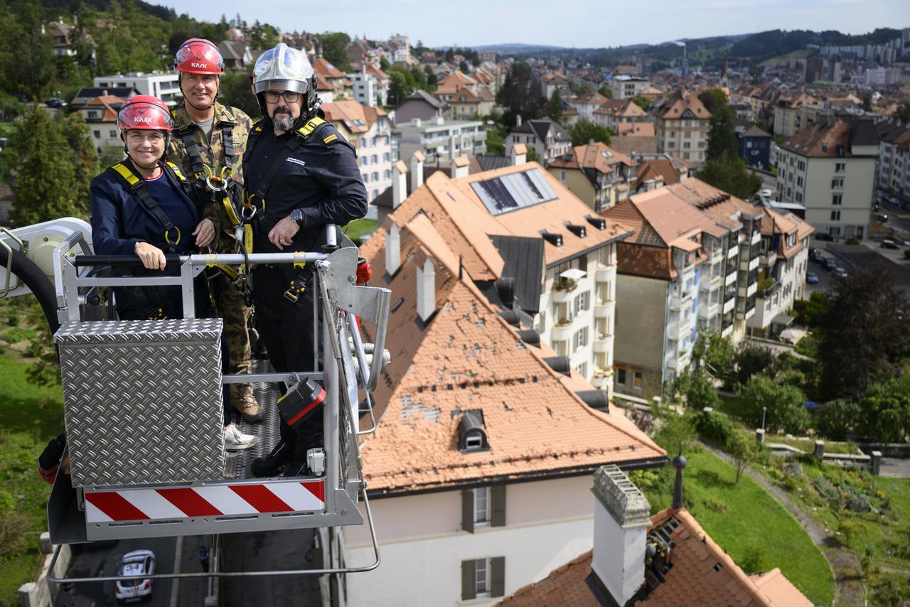 Le Divisionaire de l'armee Suisse Mathias Tüscher (au centre) avec la conseillère fédérale en charge de la Défense Viola Amherd, après la tempête à La Chaux-de-Fonds (NE), le 15 août 2023. [KEYSTONE - LAURENT GILLIERON]