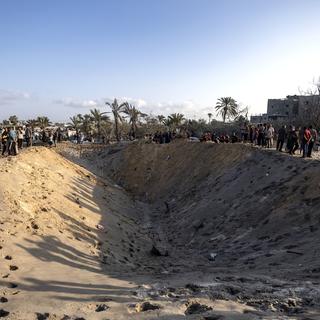 Palestinians inspect a crater as they search for missing people following Israeli airstrikes on a designated humanitarian zone of Al-Mawasi, west of Khan Younis, southern Gaza Strip, 10 September 2024. According to Gaza's civil emergency service, at least forty people were killed and more than 60 injured, with many still trapped under the rubble, following the Israeli army's airstrikes early on 10 September. The Israeli army said it targeted a Hamas command center in the Al-Mawasi area. [Keystone - EPA/HAITHAM IMAD]