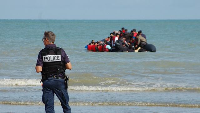 Un policier se tient sur une plage de Sangatte, dans le nord de la France, lors d'une opération visant à empêcher un canot pneumatique transportant des migrants de traverser la Manche pour rejoindre le Royaume-Uni. [AFP - BERNARD BARRON]