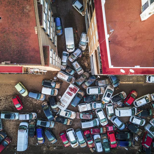 Des véhicules empilés dans les rues après les inondations causées par la tempête qui a fait des centaines de morts et de disparus à Alfafar, dans la région de Valence, en Espagne, le 2 novembre 2024. [KEYSTONE - ANGEL GARCIA]