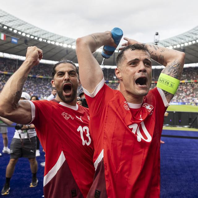 Ricardo Rodriguez et Granit Xhaka,célébrant la victoire face à l'Italie 2-0 contre l'Italie en huitièmes de finale de l'Euro 2024, le 29 juin 2024. [Keystone - Peter Klauzner]