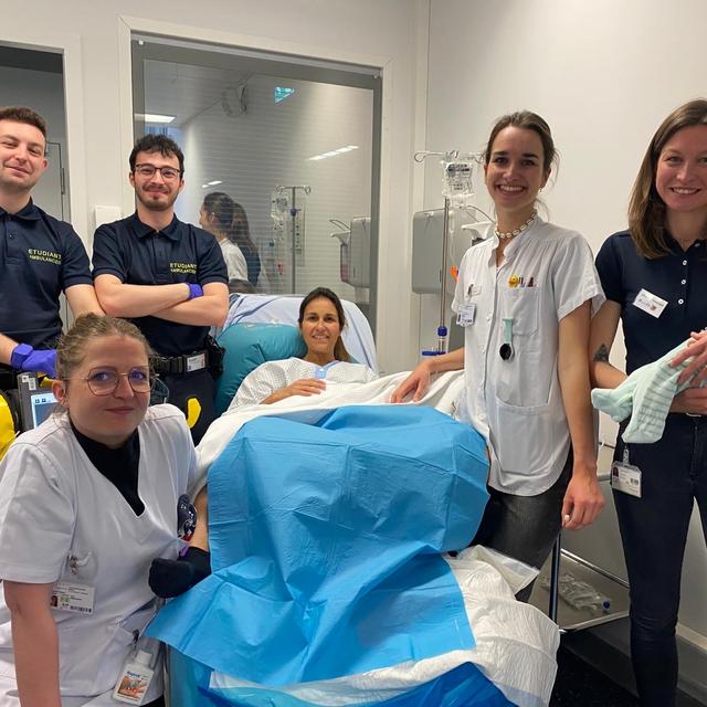 Des étudiants ambulanciers et des étudiantes sages-femmes posent en compagnie de leur "patiente simulée" au CiS à Genève. [RTS - Cécile Guérin]