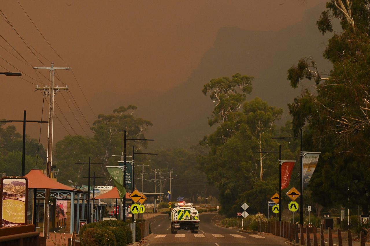 Un véhicule de pompier à Halls Gap, en Australie, le 22 décembre 2024. Des ordres d'évacuation immédiate ont été mis en place dans les villes de l'État du Victoria, alors que des incendies hors de contrôle et des températures étouffantes marquent le début de la saison des feux de brousse en Australie. [KEYSTONE - JAMES ROSS]