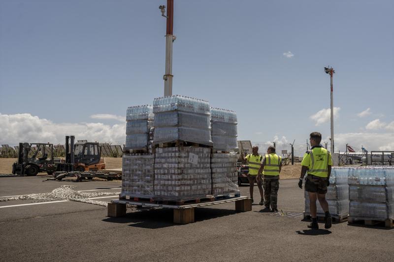 En attendant le rétablissement de l'eau courante, la France a envoyé des dizaine de palette de bouteille d'eau par avion à Mayotte. [KEYSTONE - ADRIENNE SURPRENANT]