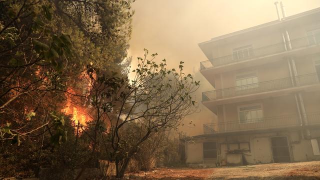 Les flammes s'approchent d'une habitation à Patima Halandri, dans la banlieue d'Athènes. [EPA/Keyston - Georges Vitsaras]