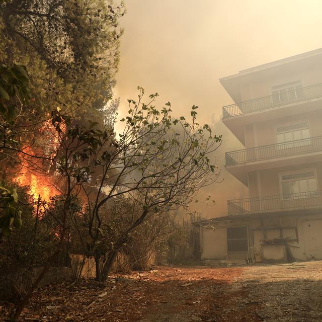 Les flammes s'approchent d'une habitation à Patima Halandri, dans la banlieue d'Athènes. [EPA/Keyston - Georges Vitsaras]