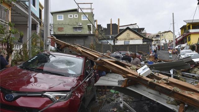 Des survivants tentant de nettoyer les rues de Mayotte, après le passage de l'ouragan Chido. 17 décembre 2024. [DICOM via AP/Keystone - Ministere de l'Interieur]