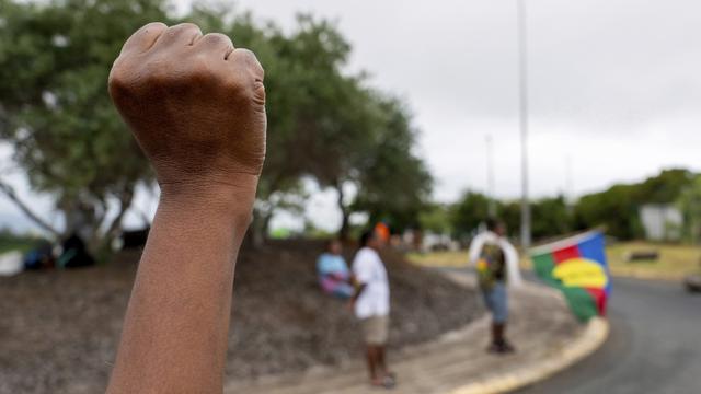 Une femme noire au poing levé en Nouvelle-Calédonie. [Keystone/AP Photo - Nicolas Job]