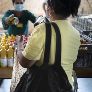 Une femme précaire reçoit un carton d'aide alimentaire vers Zurich (image d'illustration). [Keystone - Gaetan Bally]