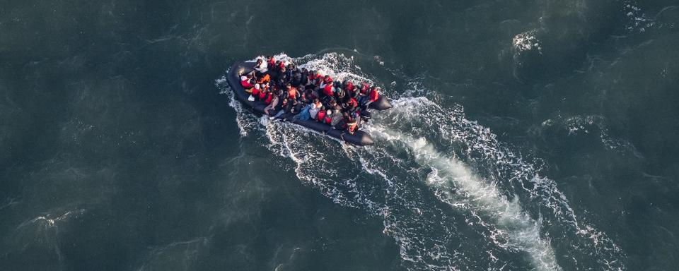 Des migrants à bord d'un canot pneumatique tentent de traverser la Manche vers le Royaume-Uni depuis une plage du Touquet, dans le nord de la France. [AFP - Sameer Al-DOUMY]