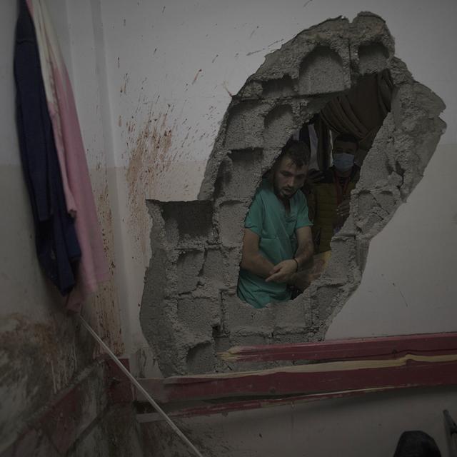 Un médecin palestinien pris dans les ruines de l'hôpital Nasser dans la ville de Khan Younès, au sud de Gaza. [Keystone/EPA - Haitham Imad]