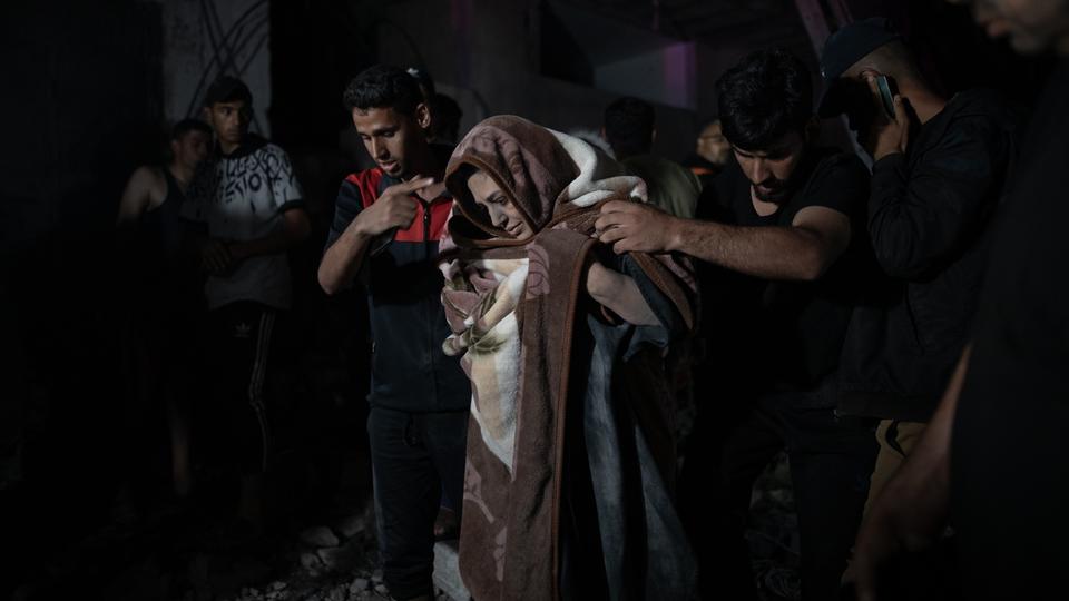 Des personnes blessées de la famille Abu Al-Anon sont évacuées de dessous des décombres après qu'une frappe aérienne israélienne ait touché leur maison dans le camp de réfugiés de Rafah, dans le sud de la bande de Gaza, le 4 mai 2024. [KEYSTONE - Haitham Imad]