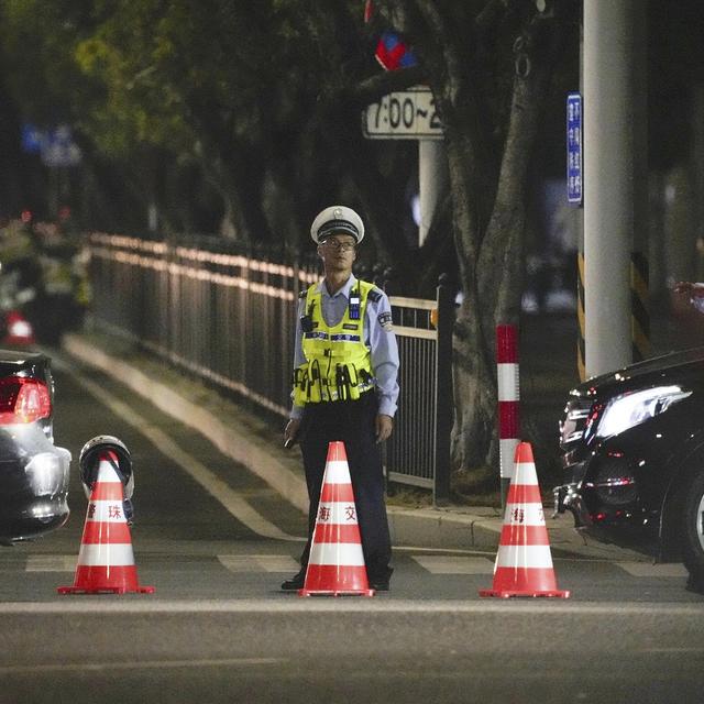 Un policier près d'un centre sportif où une attaque à la voiture-bélier a fait au moins 35 victimes. [Keystone/Kyodo News via AP]