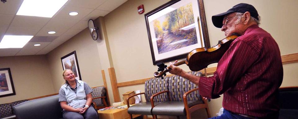 Un homme joue du violon dans un hôpital américain. [Keystone/AP Photo/Missoulian - Michael Gallacher]