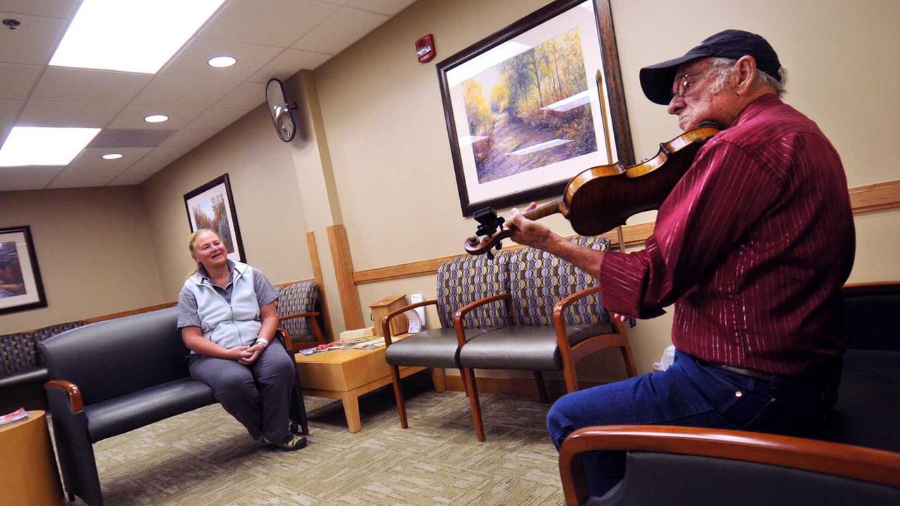 Un homme joue du violon dans un hôpital américain. [Keystone/AP Photo/Missoulian - Michael Gallacher]