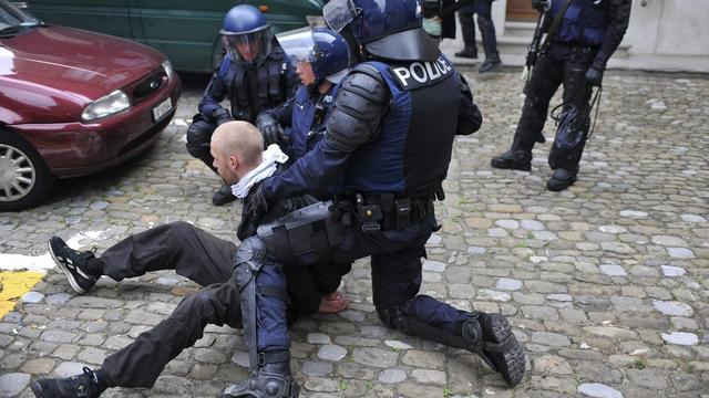 Des policiers qui arrêtent un homme pendant une manifestation contre la violence policière à Fribourg. [Keystone/La Liberté - Alain Wicht]