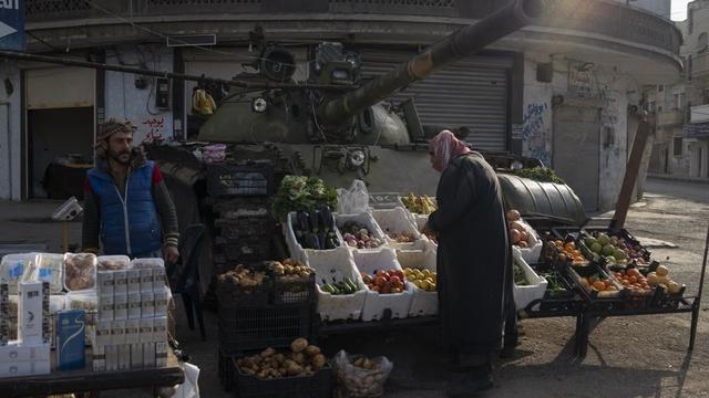 Un marché rudimentaire installé sur un tank à Homs, en Syrie. [Keystone - AP Photo/Leo Correa]