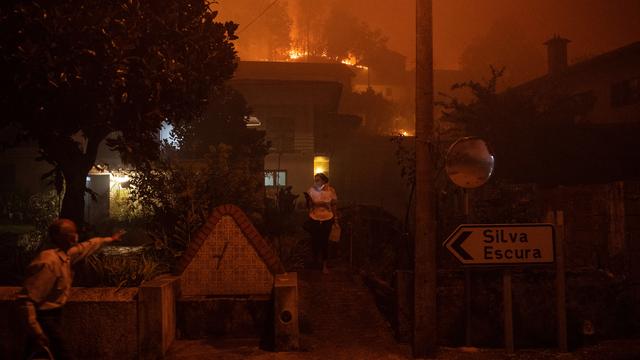 Une femme appelle à l'aide alors qu'un incendie de forêt s'approche de sa maison à Ribeira de Fraguas, le 16 septembre 2024. [AFP]