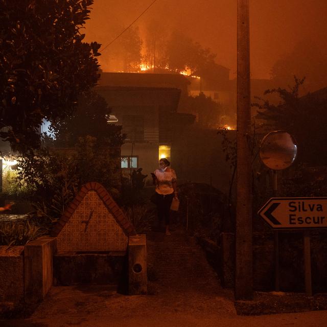 Une femme appelle à l'aide alors qu'un incendie de forêt s'approche de sa maison à Ribeira de Fraguas, le 16 septembre 2024. [AFP]