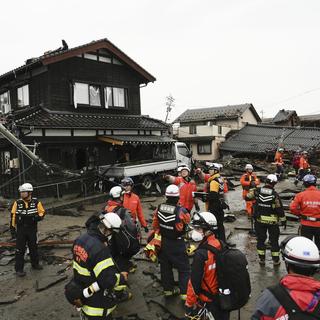 Des policiers et des pompiers au Japon après le séisme, le 3 janvier 2024. [Keystone - Kyodo News via AP]