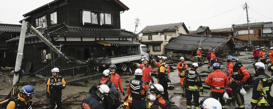 Des policiers et des pompiers au Japon après le séisme, le 3 janvier 2024. [Keystone - Kyodo News via AP]