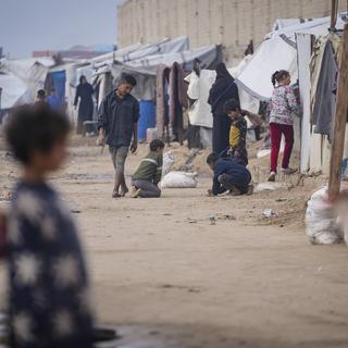 Des enfants palestiniens jouant dans un camp de déplacés à Deir al-Balah, au centre de la Bande de Gaza. 16 janvier 2025. [AP Photo/Keystone - Abdel Kareem Hana]