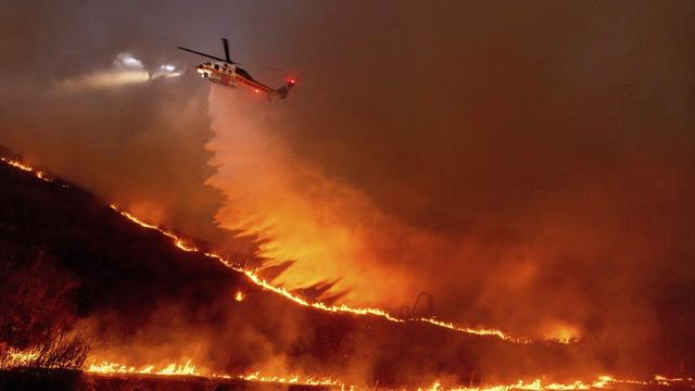 De l'eau déversé depuis un hélicoptère lors de l'incendie historique de Los Angeles. 9 janvier 2025. [AP Photo/Keystone - Ethan Swope]