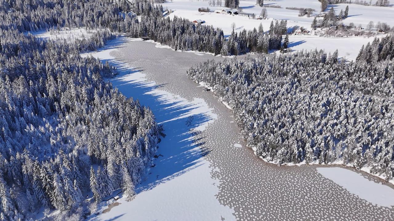 Vue par drone de l'étang de la Gruère en partie gelé. [RTS]