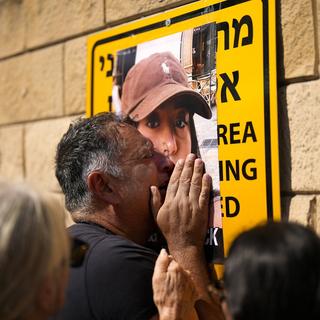 Le père de Liri Albag, otage du Hamas, pleurant devant un portrait de sa fille lors d'une manifestation à Tel Aviv, Israël. Le 14 octobre 2023. [AP Photo/Keystone - Francisco Seco]