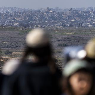 Des silhouettes observent la bande de Gaza détruite depuis un point de vue à Sderot, au sud de l'Israël. [AP Photo/Keystone - Ariel Schalit]