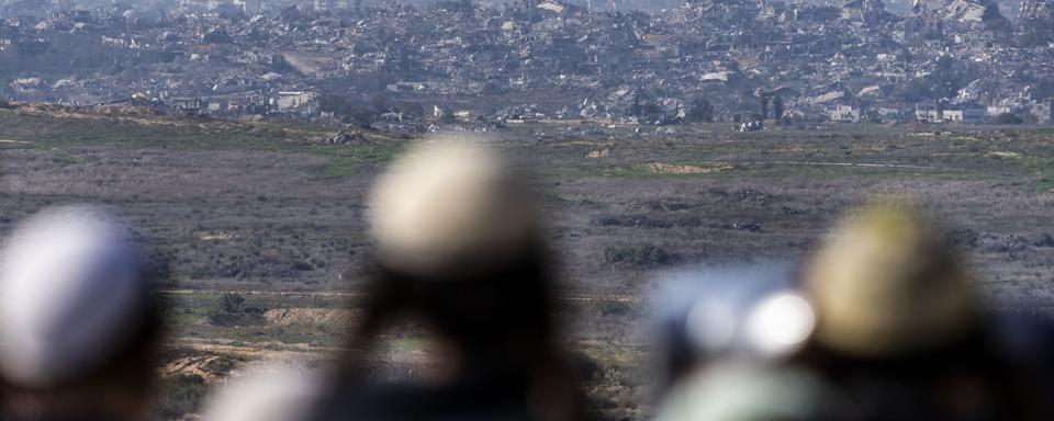 Des silhouettes observent la bande de Gaza détruite depuis un point de vue à Sderot, au sud de l'Israël. [AP Photo/Keystone - Ariel Schalit]