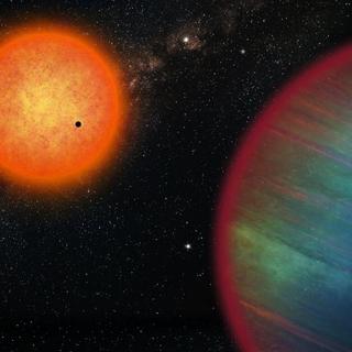 Le système WASP-132 ne contient pas seulement la Jupiter chaude WASP-132b, mais d'autres planètes dont une super-Terre, vue en train de transiter devant l'étoile-hôte orange (de type K), et une planète glacée, WASP-132d (le petit point bleu dans le coin supérieur droit). [UNIGE - Vision d'artiste par Thibaut Roger]