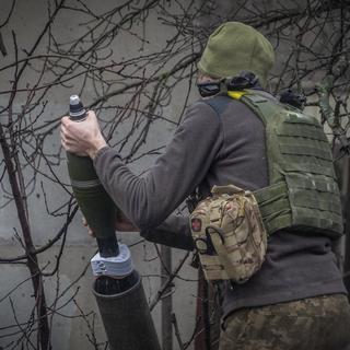 Un soldat ukrainien prépare un tir de mortier contre des positions russes près de Kharkiv en Ukraine. (image d'illustration) [AP Photo/Keystone - Andrii Marienko]