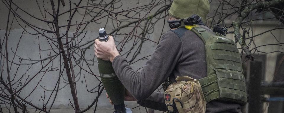 Un soldat ukrainien prépare un tir de mortier contre des positions russes près de Kharkiv en Ukraine. (image d'illustration) [AP Photo/Keystone - Andrii Marienko]