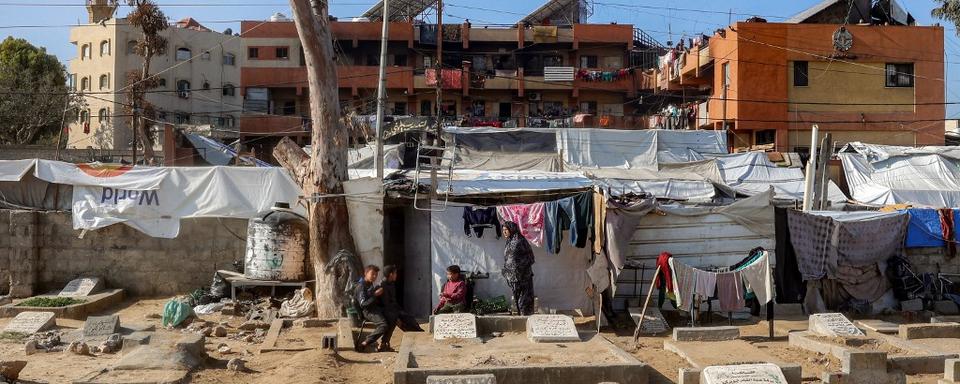 Une femme et des enfants dans un camp de réfugiés dans la bande de Gaza. [AFP - Eyad BABA]