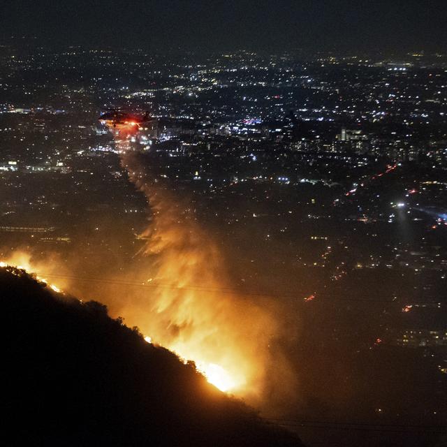 De l'eau est larguée par hélicoptère sur l'incendie dans la section Hollywood Hills de Los Angeles, mercredi 8 janvier 2025. [Keystone - Ethan Swope]