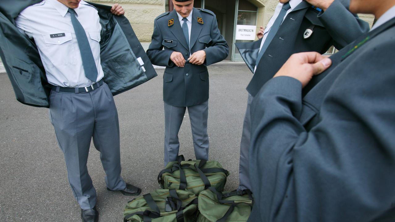 Des militaires ajustent leur tenue de sortie. [Keystone - Martin Ruetschi]