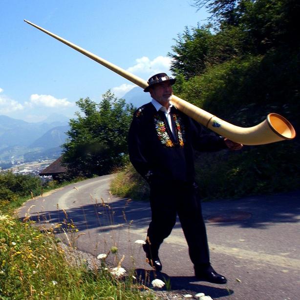 Joueur de cor des Alpes se promenant dans la nature afin d'y jouer. [Olivier Maire]